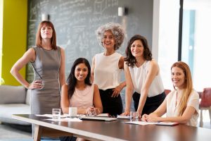 Profissionais diversas em reunião estratégica discutindo sustentabilidade corporativa e desenvolvimento organizacional